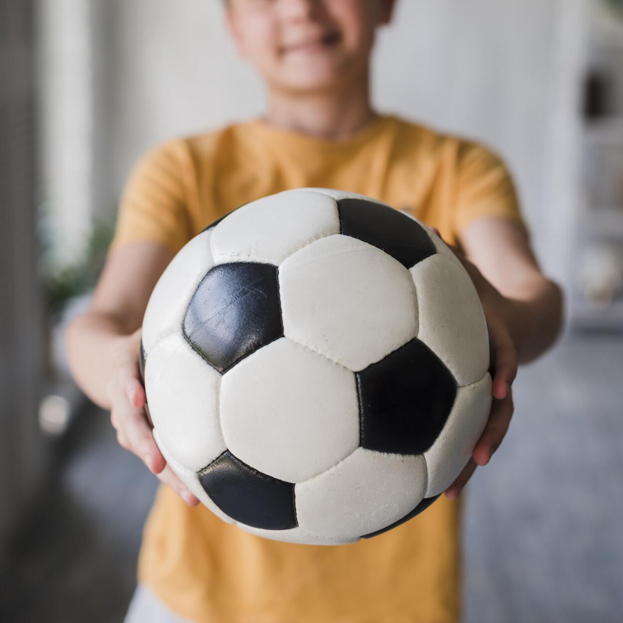 close-up-boy-giving-soccer-ball-toward-camera